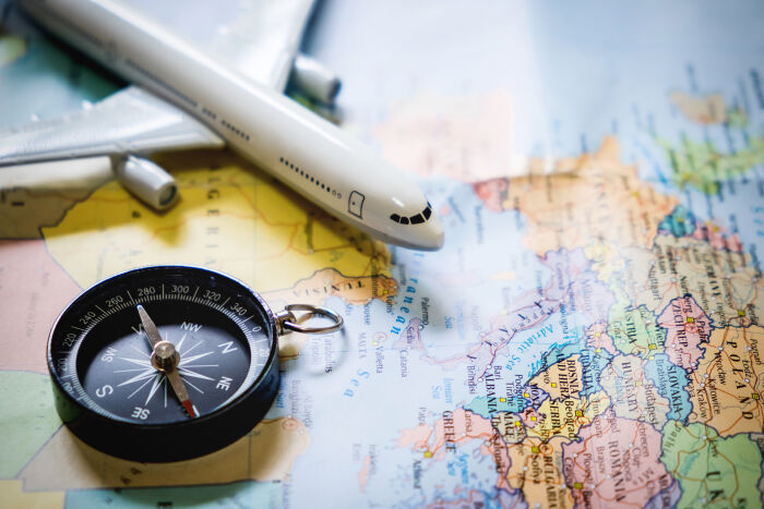 selective-focus-miniature-tourist-compass-map-with-plastic-toy-airplane-abstract-background-travel-concept.jpg